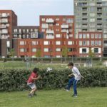 spelende kinderen met een rij huizen op achtergrond